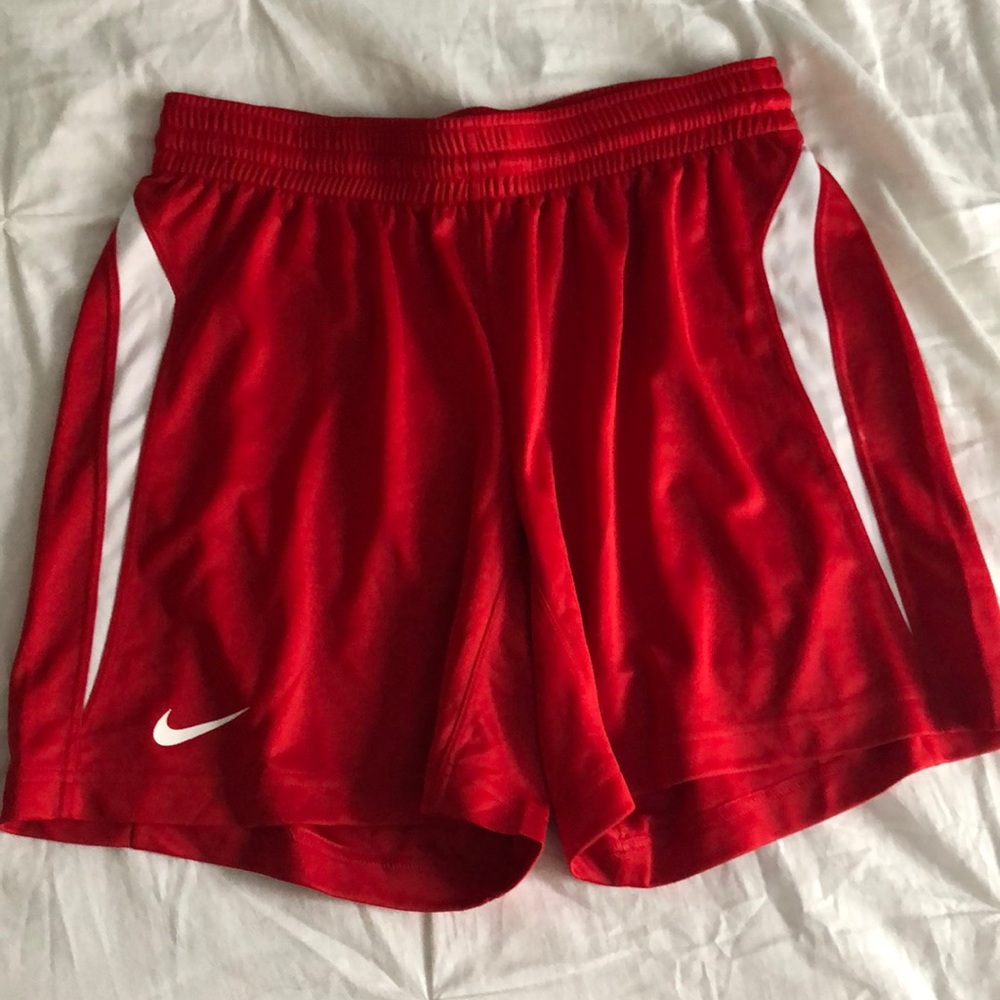 red nike shorts with white swish.